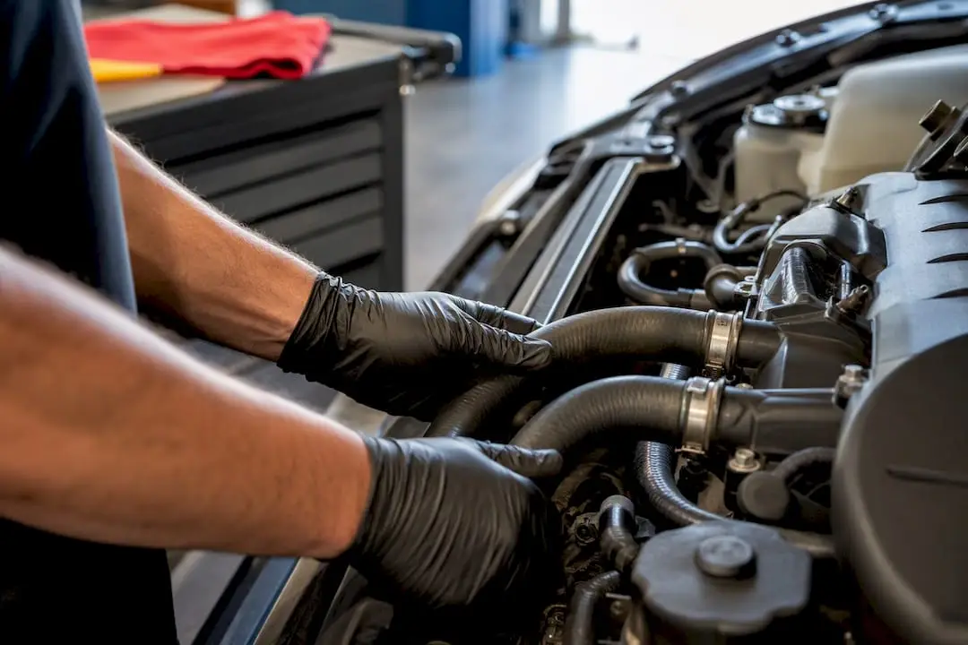 Technician checking automotive heater hoses