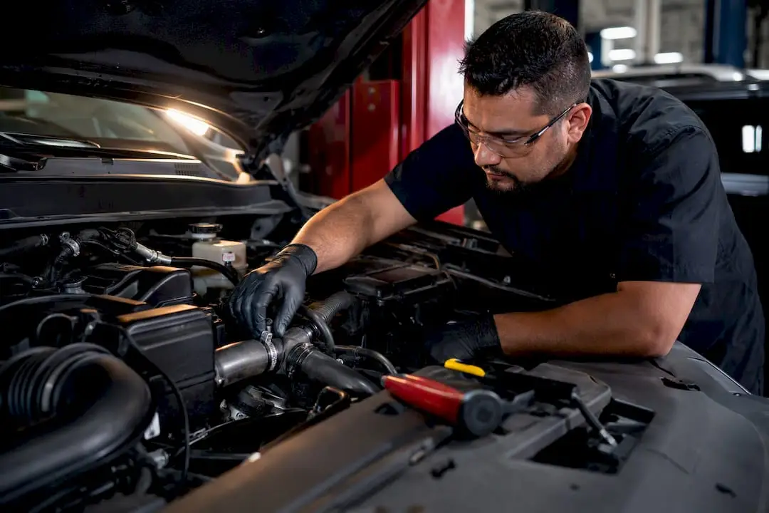 Technician inspecting an automotive thermostat housing